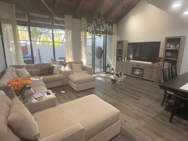 living area with lofted ceiling with beams, an inviting chandelier, wooden ceiling, and wood finished floors