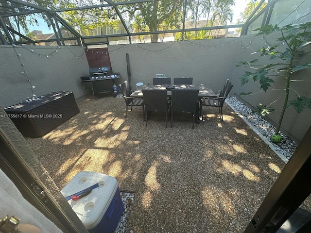 view of patio featuring glass enclosure, grilling area, and outdoor dining space