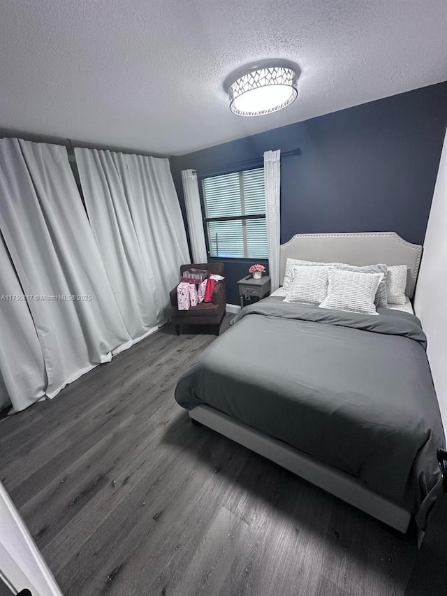 bedroom with a textured ceiling and wood finished floors