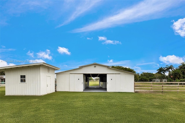 back of property with an outbuilding, a yard, fence, a carport, and a pole building