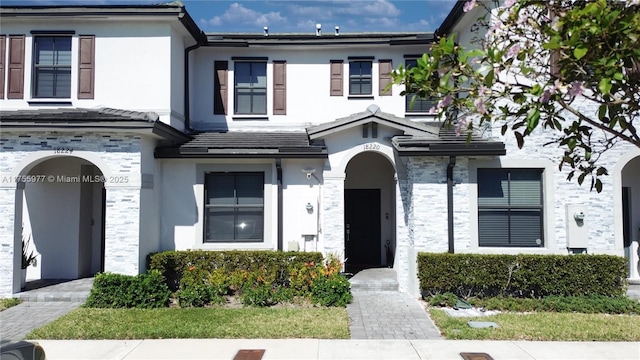 townhome / multi-family property with stone siding and stucco siding