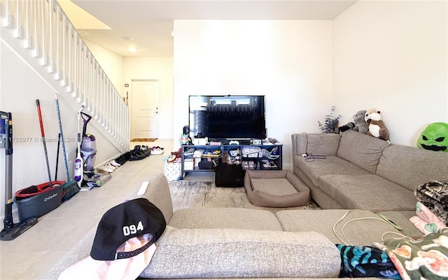 living area featuring stairway and tile patterned flooring