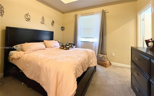 bedroom featuring light carpet and baseboards