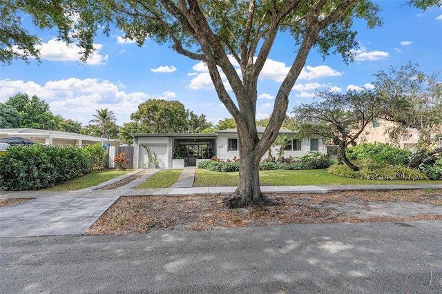 view of front of home with an attached garage, driveway, and a front lawn