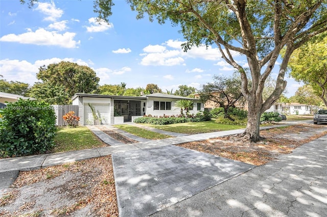 view of front of property featuring an attached garage, concrete driveway, and a front yard