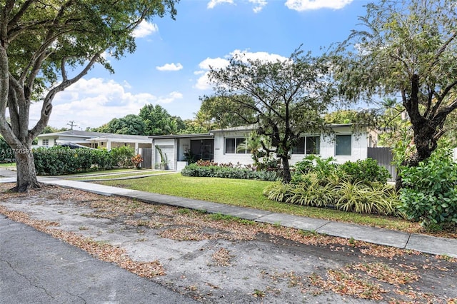 ranch-style home with a garage, concrete driveway, and a front lawn