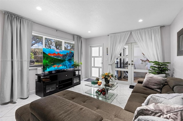 living room featuring a healthy amount of sunlight, french doors, and tile patterned floors