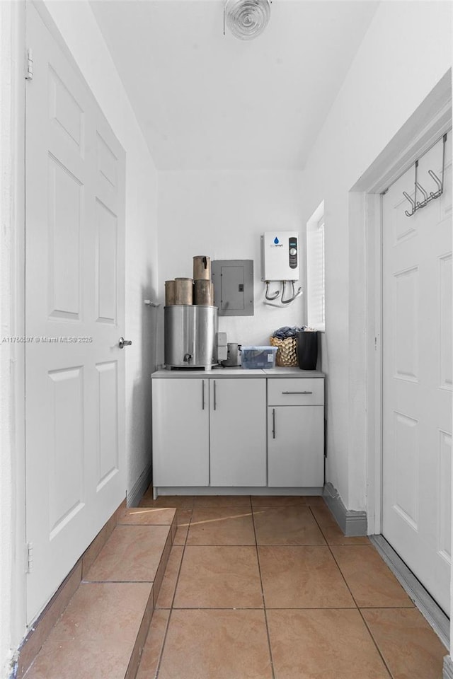 kitchen with electric panel and light tile patterned floors