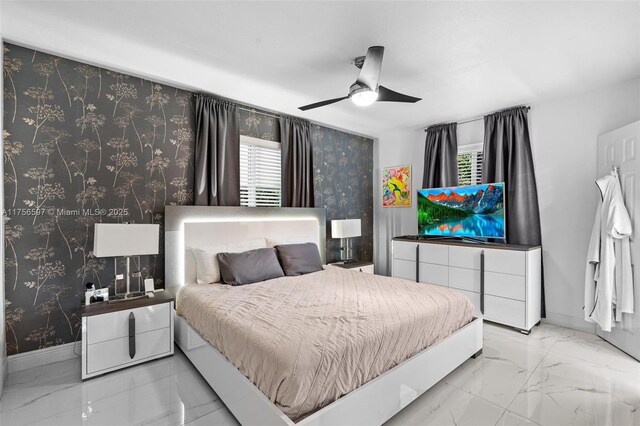 bedroom with baseboards, marble finish floor, wallpapered walls, and ceiling fan