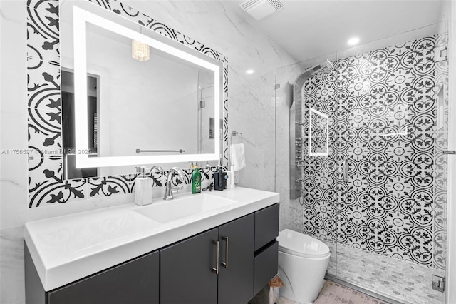 bathroom with visible vents, toilet, a stall shower, and vanity