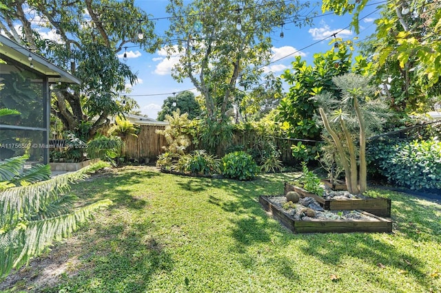 view of yard featuring fence and a garden