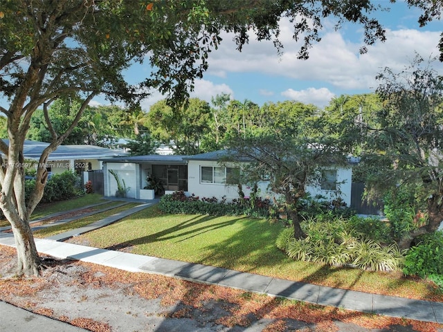 ranch-style house with an attached garage, driveway, and a front lawn