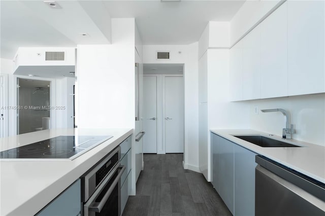 kitchen featuring a sink, visible vents, white cabinets, appliances with stainless steel finishes, and modern cabinets