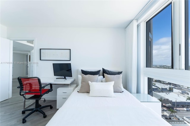 bedroom featuring multiple windows and wood finished floors