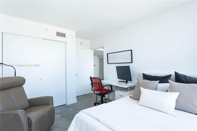 bedroom featuring a closet, wood finished floors, and visible vents