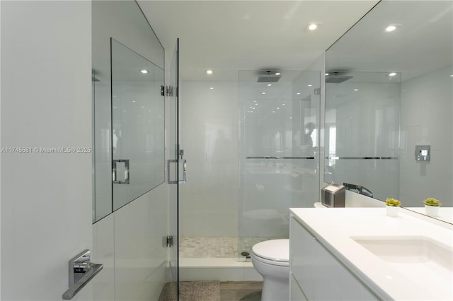 bathroom with vanity, a shower stall, toilet, and recessed lighting