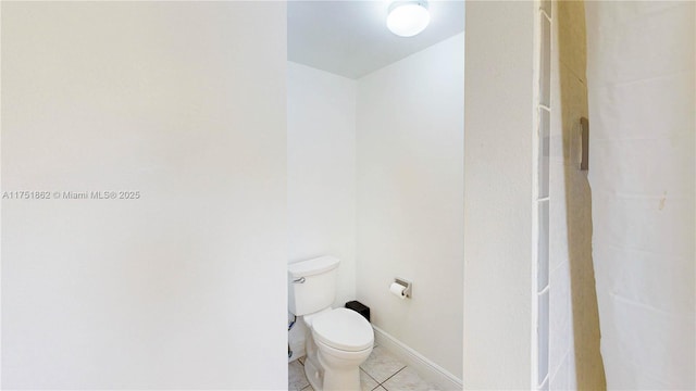 bathroom featuring tile patterned flooring, toilet, and baseboards