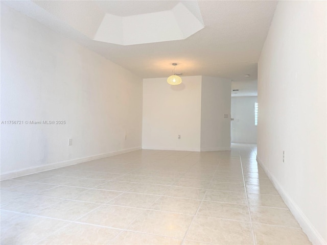 spare room with baseboards and light tile patterned floors