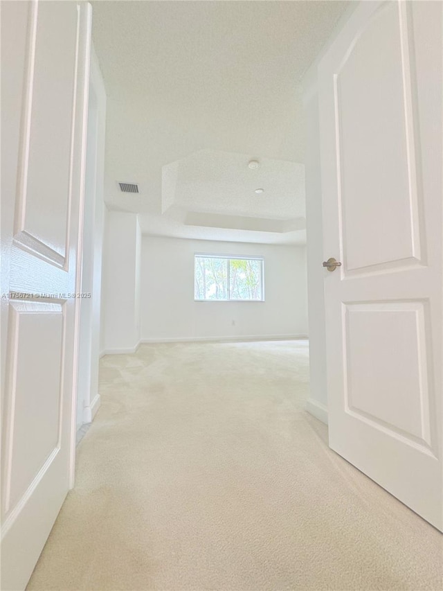 spare room with baseboards and light colored carpet