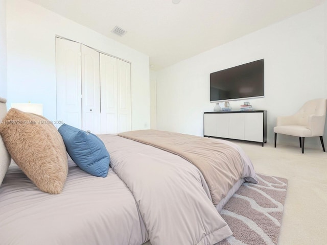 carpeted bedroom with a closet and visible vents