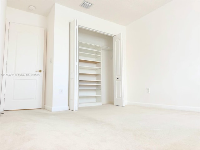 unfurnished bedroom with baseboards, a closet, visible vents, and carpet flooring