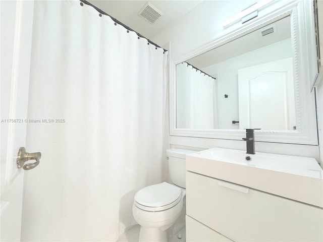 bathroom featuring curtained shower, visible vents, vanity, and toilet