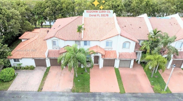 view of front facade with a garage, driveway, and a tile roof