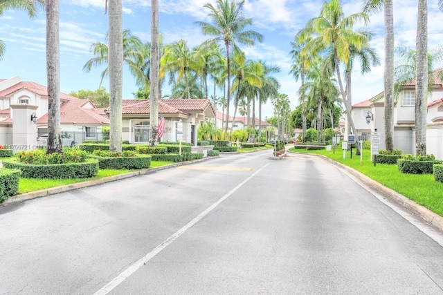 view of road with a residential view, a gated entry, and curbs