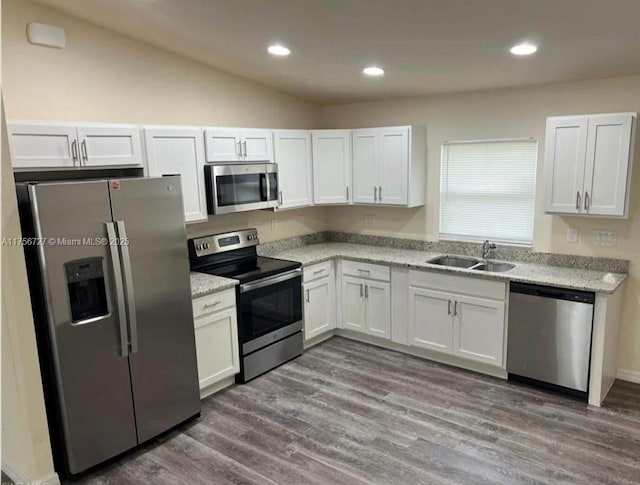 kitchen featuring dark wood finished floors, recessed lighting, appliances with stainless steel finishes, white cabinetry, and a sink