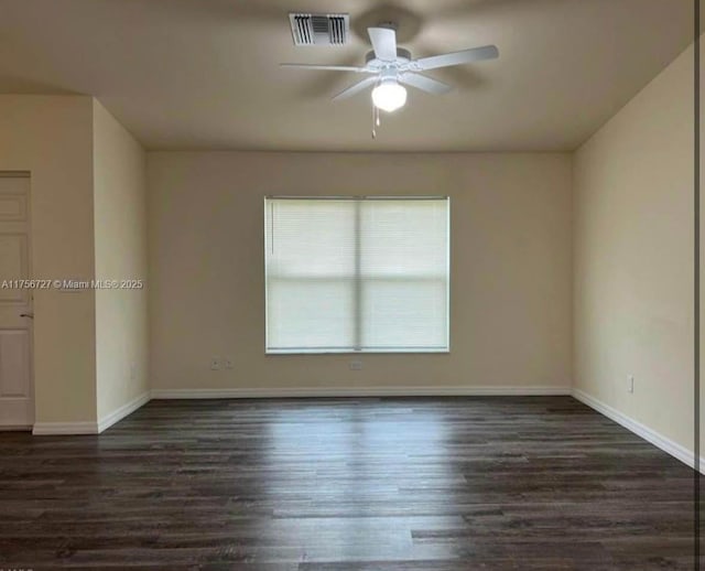 empty room with a ceiling fan, wood finished floors, visible vents, and baseboards