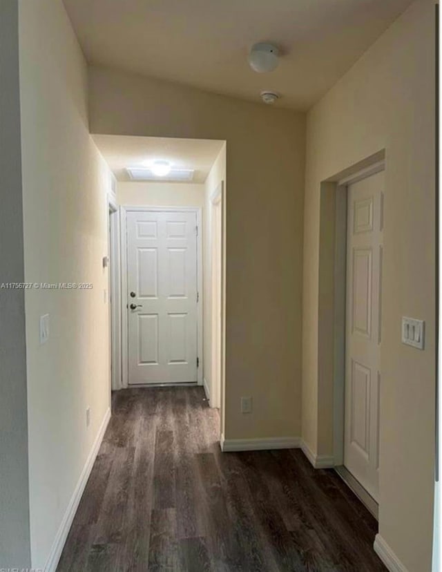 corridor featuring dark wood-style floors and baseboards