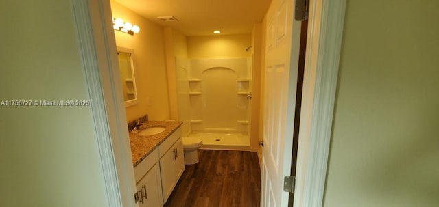 full bathroom featuring visible vents, toilet, a shower stall, vanity, and wood finished floors