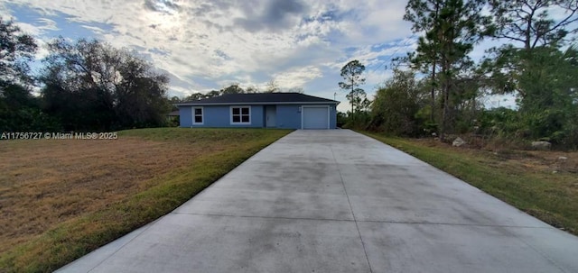 single story home with a front lawn, driveway, and an attached garage