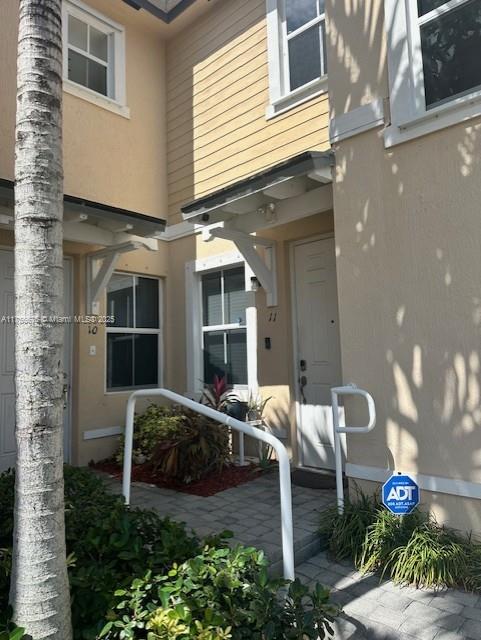 doorway to property featuring stucco siding