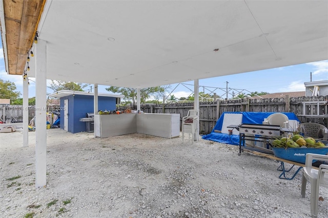 view of patio / terrace with an outbuilding, a fenced backyard, and grilling area