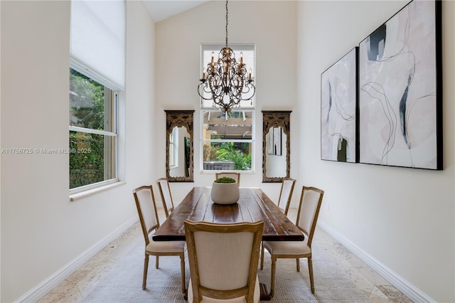 dining room with baseboards, vaulted ceiling, and a notable chandelier