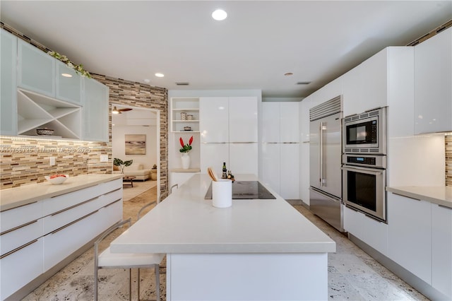 kitchen featuring a center island, modern cabinets, white cabinetry, and built in appliances