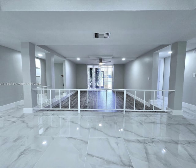 empty room with marble finish floor, recessed lighting, visible vents, and baseboards