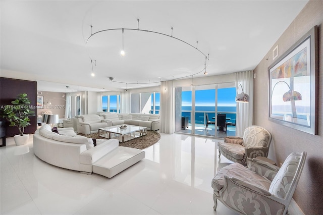 living room featuring tile patterned floors, visible vents, and a water view