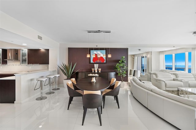 dining room featuring an accent wall and visible vents