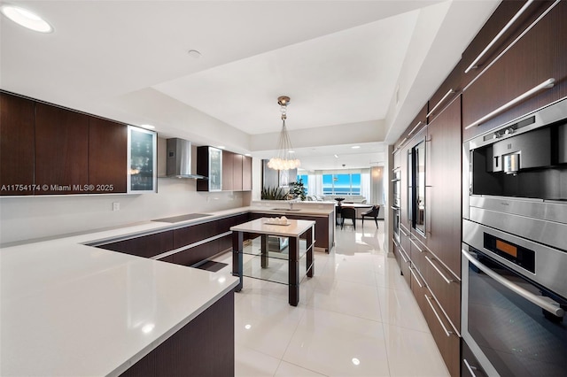 kitchen with dark brown cabinets, wall chimney exhaust hood, oven, and black electric cooktop