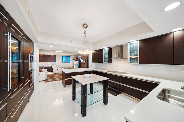 kitchen with dark brown cabinets, light countertops, modern cabinets, wall chimney exhaust hood, and black electric cooktop