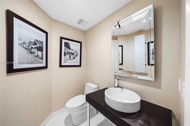 bathroom with vanity, toilet, and visible vents