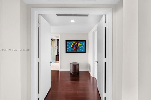 hallway featuring visible vents, recessed lighting, dark wood-type flooring, and baseboards