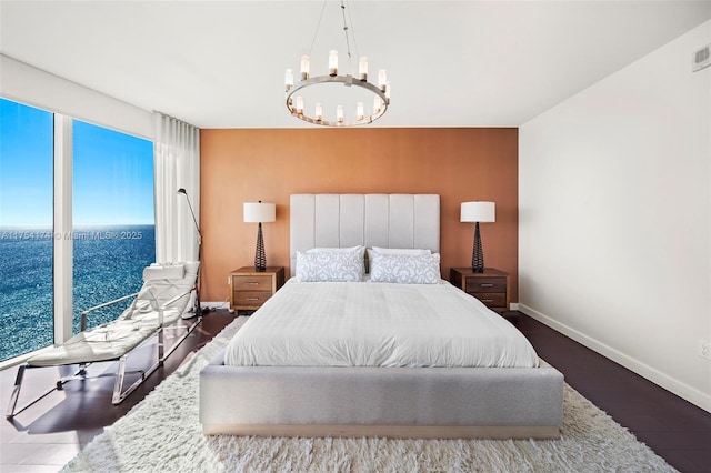 bedroom featuring visible vents, an inviting chandelier, baseboards, and wood finished floors