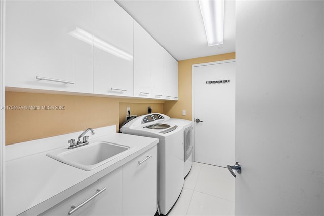 laundry area featuring separate washer and dryer, light tile patterned floors, cabinet space, and a sink