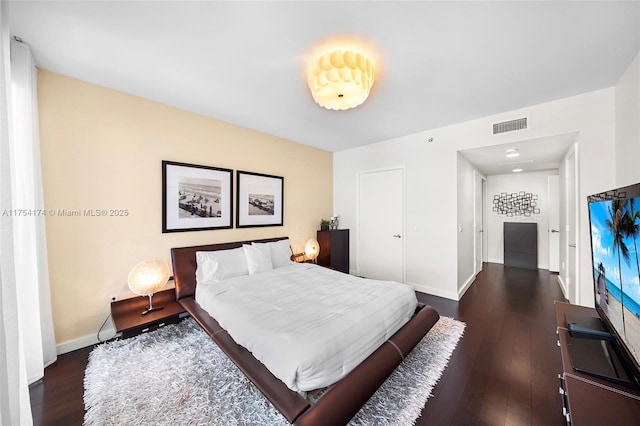 bedroom with visible vents, baseboards, and dark wood-style floors