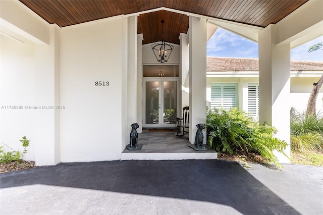 property entrance with stucco siding and french doors