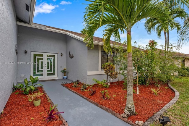 property entrance with french doors and stucco siding