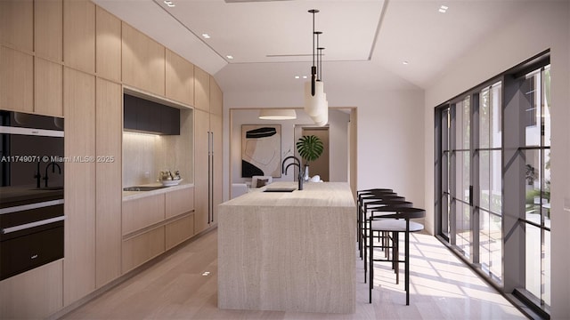 kitchen featuring lofted ceiling, light brown cabinetry, modern cabinets, and a sink